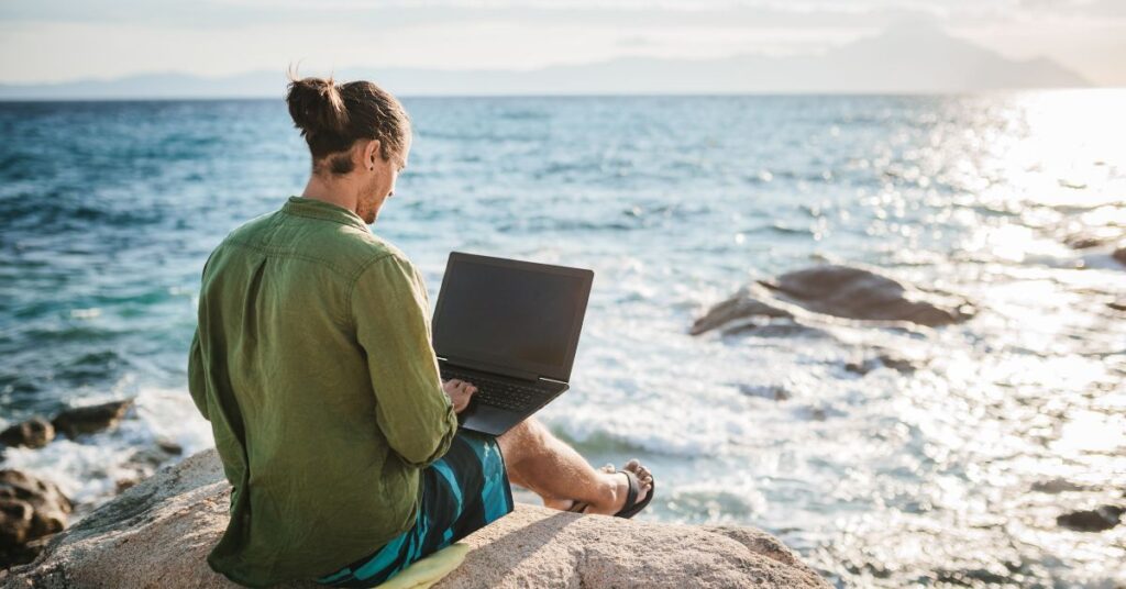 Digital nomad working overlooking the sea