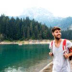 US expat hiking by a lake.