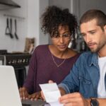 Expat couple at a laptop working out their Foreign Housing Exclusion