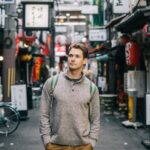 US expat living in Japan walks down a busy city street