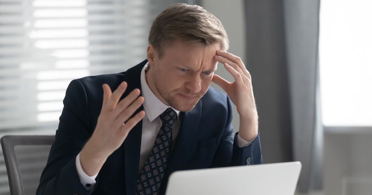 Frustrated US expat stares at his laptop screen trying to understand his US tax obligations