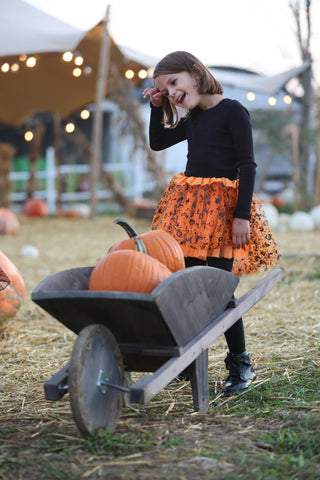 Girl with pumpkins in a wheelbarrow at an autumn festival