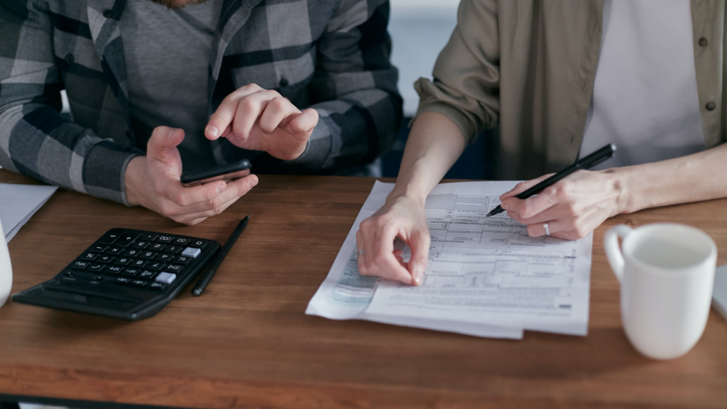 Two people sitting at a wooden desk checking for FATCA exemptions